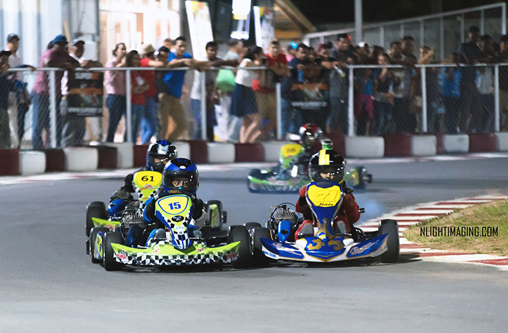 Wheel-to-wheel action as Paige Mendonca (kart 15) leads Nathan Rahaman (71) during the Sunburst 60cc Kids Cup at the Georgetown Grand Prix last Friday.  (NLightimaging photo)