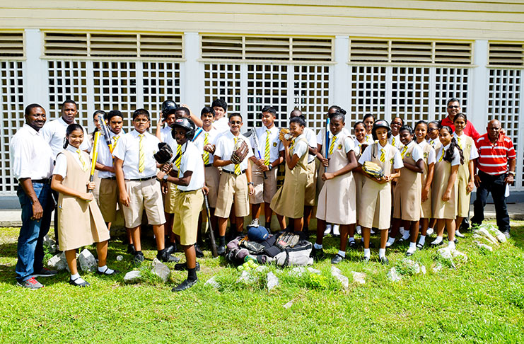 The third form students pose with their new baseball equipment. Also in photo is president of the Guyana Baseball League, Robin Singh (second right), Queen’s College games’ master, Christopher Barnwell (right), Baseball coach, Devon Douglas (left) and Queen’s College Physical Education teacher, Osafo Dos Santos  (second left).