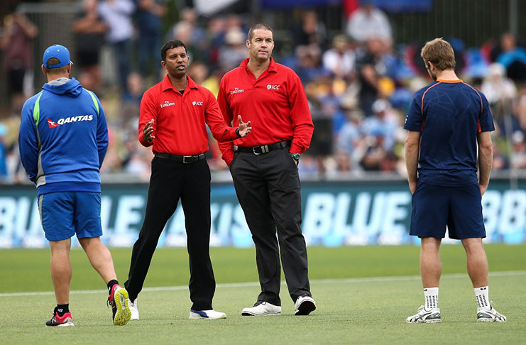 Umpires Kumar Dharmasena and Chris Brown speak to the two captains.