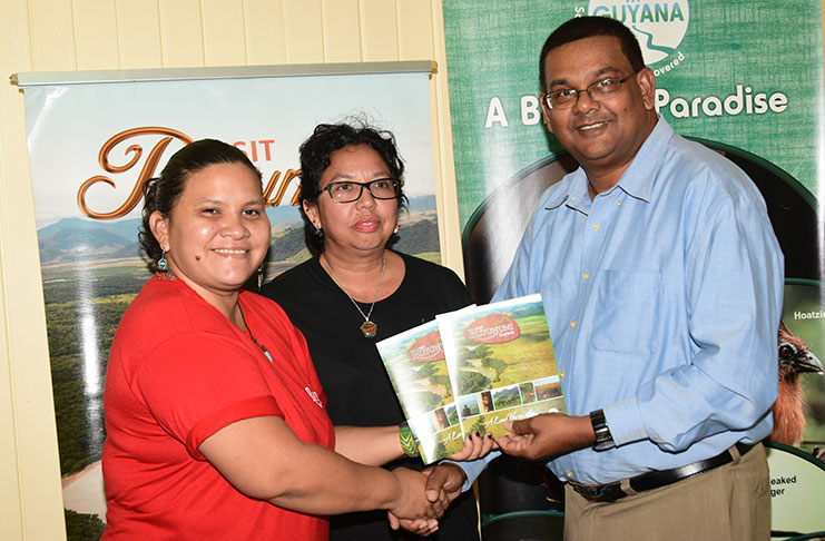 The Visit Rupununi team hands over the guide to the GTA Director