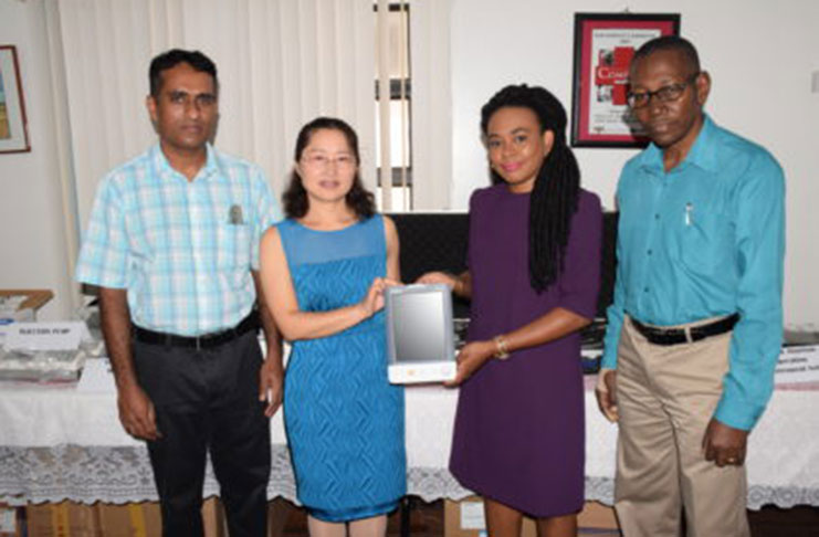 From Left to right: Head of the Orthopaedics Unit, Georgetown Public Hospital Corporation (GPHC) Dr. David Samaroo and Head of the 12th Chinese Medical Brigade, Dr. Lianhau Chen,handing over one of the vital monitors to chairperson of the GPHC Board of Directors, Kesaundra Alves and Chief Executive Officer (CEO), GPHC, Allan Johnson