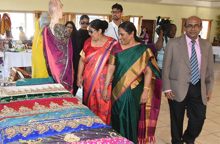 From right: Indian High Commissioner to Guyana Venkatachalam Mahalingam; his wife Anu; and wife of Prime Minister, Moses Nagamootoo, Sita Nagamootoo, browsing the sari on display at the event