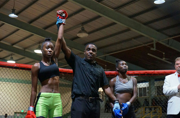 Shenese Bobb with her competitor and the referee after her win in
Trinidad recently