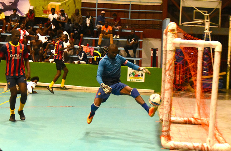 Tense action occurs on Tuesday evening in the GT Beer/Petra Futsal tournament at the National Gymnasium. (Adrian Narine photo)