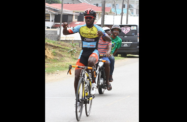Shaquel Agard is jubilant as he crosses the finish line at Tain, Corentyne, Berbice, to win the 20th edition of the Dr. Cheddie Jagan Cycle Road Race yesterday.