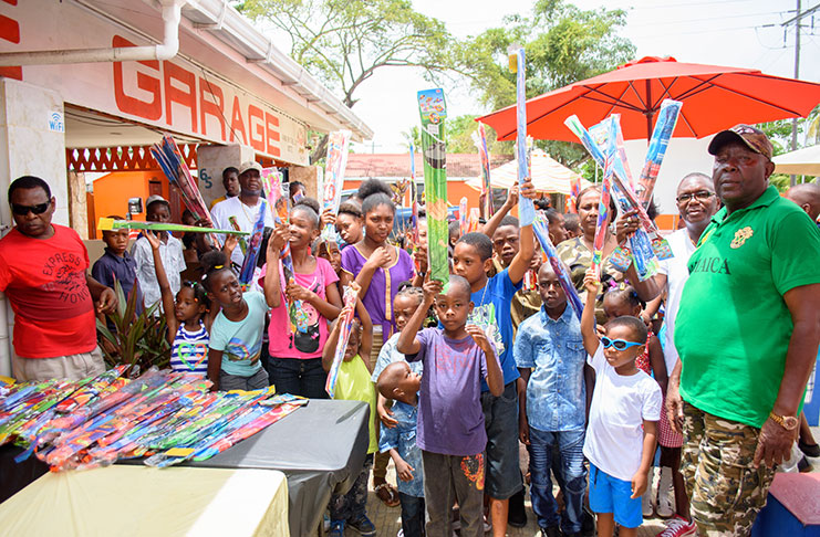 Owner of ‘The Garage’, Mr Estwick Northe (left) shares a moment with the boisterous children on Sunday