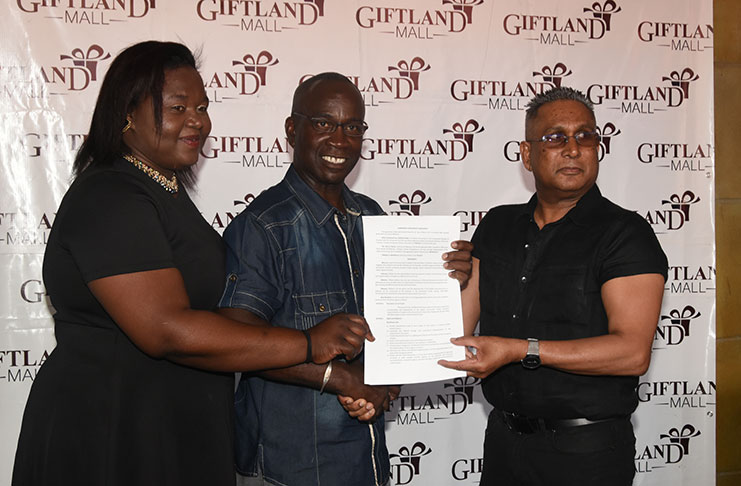 Giftland Mall Chairman Roy Beepat, Sophia resident Odessa Primus and Pattensen Development Council Chairman Colin Marks display the signed contract on Friday