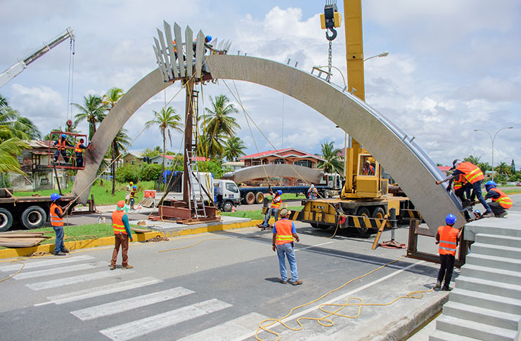 Workers installing the arch at Industry, East Coast Demerara, yesterday [Samuel Maughn photo]