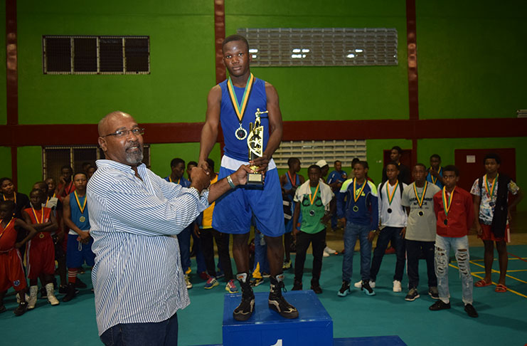 Guyana’s Shaquille Wright receives his Best Boxer award at the conclusion of the second edition of the Caribbean Schoolboys and Juniors boxing championships at the National Gymnasium on Sunday evening. (Cullen Bess-Nelson photos)