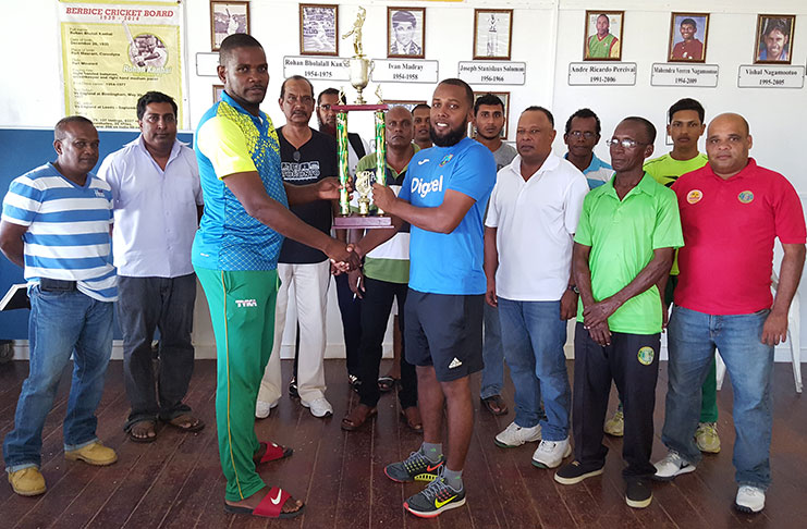 BCB Competitions Committee member, Godwin Allicock, who also represented the sponsor, hands over the winning trophy to National Under-15 coach, Julian Moore. Also sharing the moment is acting BCB executives along with club representatives.
