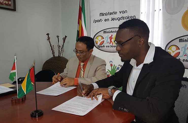 Director of Sport for Suriname Luciano Memgmikrom (left) and Guyana’s Christopher Jones signing the protocol for the 2017 IGG.