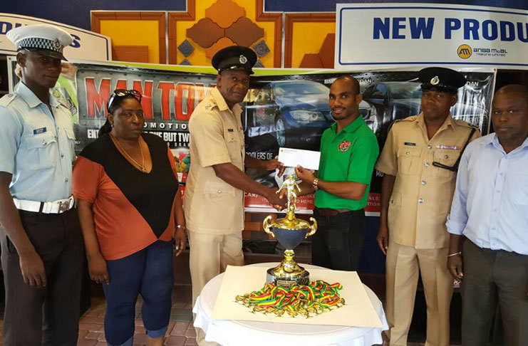 Stag Brand Manager,Lindon Henry (3rd right) hands over the cheque to ASP Forbes Brown in the presence of,from right:WDFA President Orin Ferrier, Inspector Andre Grant, WDFA VP,Christine Schmidt and GPF FC player, Devon Brown.