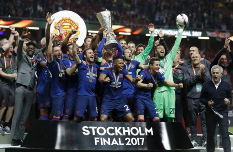 Manchester United celebrate winning the Europa League with the trophy. (Reuters/Andrew Couldridge)