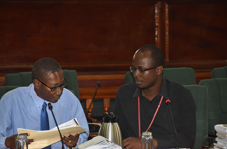 GPHC’S CEO, Allan Johnson, (L) speaks with Finance Director, Ronald Charles, (R) on Monday during a PAC meeting as questions were thrown to them about the financial operation of the entity (Adrian Narine photo)