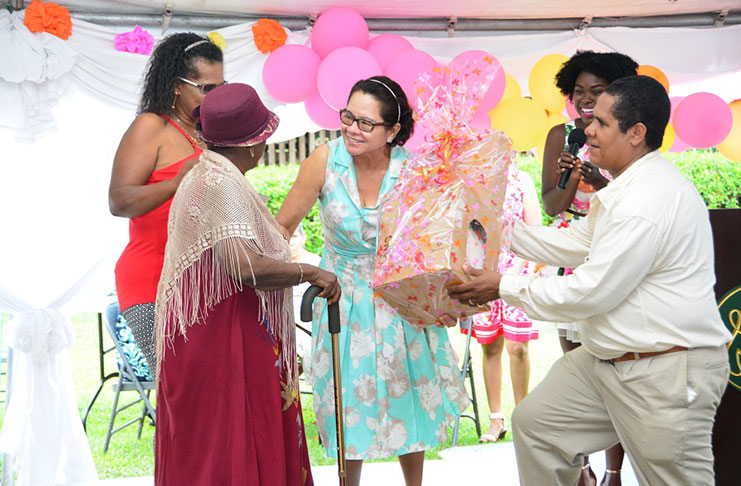 First Lady Mrs Sandra Granger presents 84-year-old Ms Elaine Bettencourt with the prize for being the mother with the most children at the event. Ms Bettencourt gave birth to 17 children, three of whom are deceased