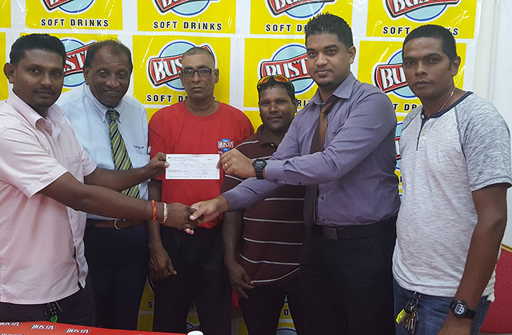 Secretary of the EBSC Chanderpaul Tickaram collects the sponsorship cheque from a representative of the Guyana Beverage Company in the presence of other club members and General Manager of the company Robert Selman.