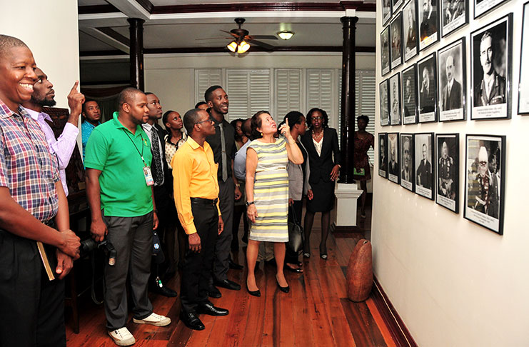 First Lady, Mrs. Sandra Granger shows members of the Guyana Youth and Student Movement (GYSM) a display of the past Governors of Guyana, during a tour of the State House.
