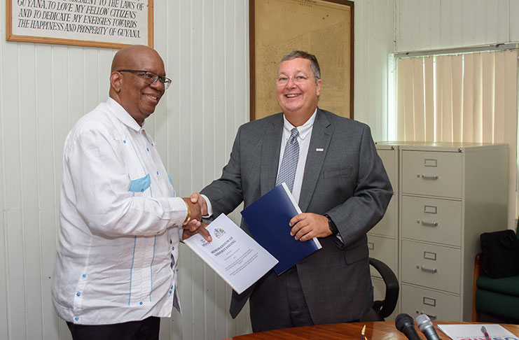 Finance Minister Winston Jordan and USAID Mission Director of the Eastern Caribbean and the Southern Caribbean, Christopher Cushing shaking hands shortly after signing the YES MoU. (Photo by Samuel Maughn)