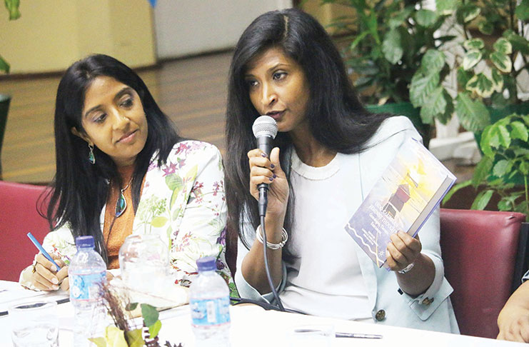 From left: Dr. Gabrielle Hosein looks on as Dr. Lisa Outar addresses the audience on the book