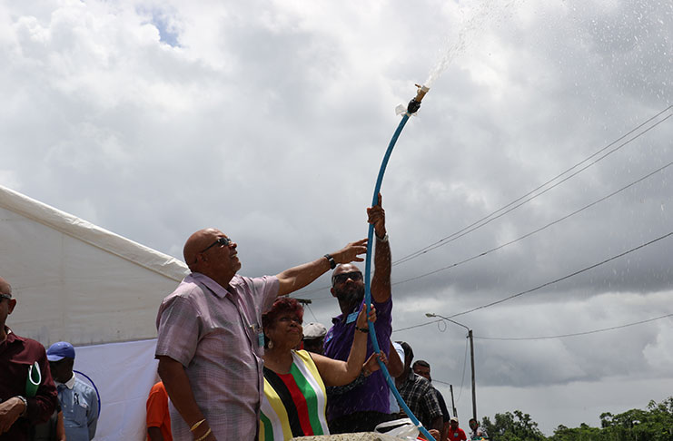 GWI Managing Director, Dr. Richard Van West-Charles; Minister of Social Protection, Amna Ally; Minister within the Ministry of Communities, Dawn Hastings-Williams; and GWI Berbice General Manager, Jeremiah enjoy spilling water for the first time out of a main at Moleson Creek, Corentyne, Berbice