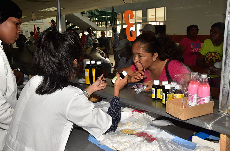 Pharmacists at the Georgetown Public Hospital (GPHC) issuing a patient with a prescribed drug on Wednesday (Photo by Adrian Narine)