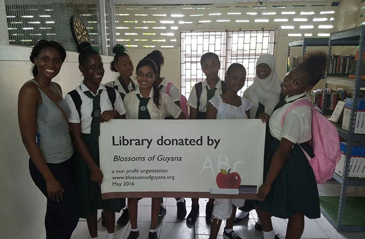 Blossoms of Guyana’s Sharon Bollers (far left) with Houston Secondary School students in their newly-renovated library