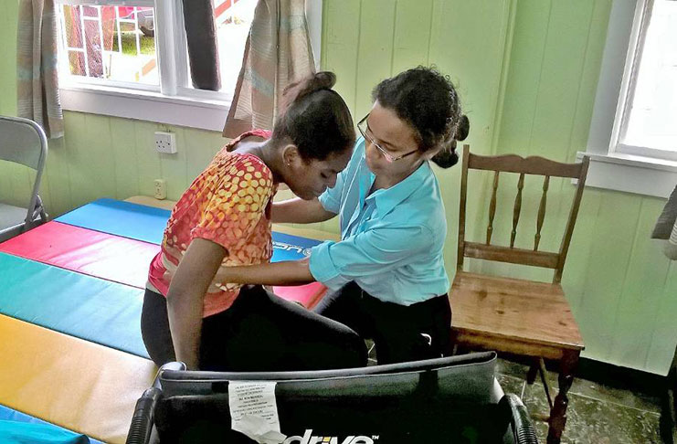 Physiotherapist Christine Alphonso assists Ronicia Martin to move from the bed to the chair.