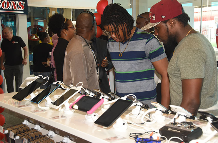 Some of the first customers of Radio Shack Guyana store examine a range of IPADs at the store at Giftland Mall, Turkeyen Friday (Adrian Narine photograph)