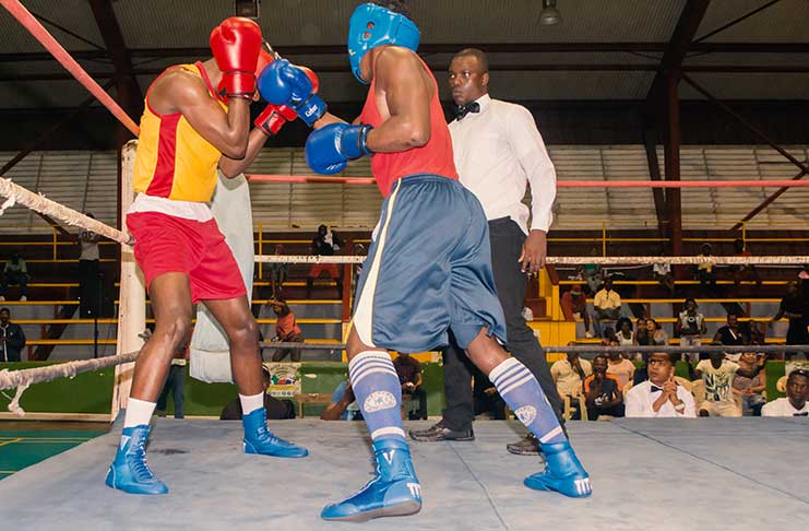 Republican’s Jamal Leitch (right) connects to the chin of GDF’s Toney Gillis during round two of their 69kg final at the National Gymnasium, Thursday night. (Photo by Samuel Maughn)