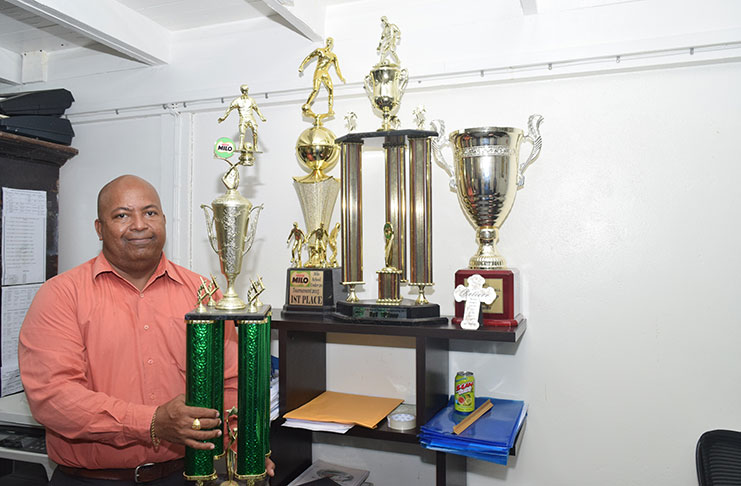 Henry Chase with some of the trophies won by the various student-athletes