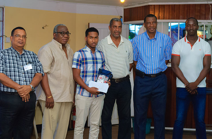Windies U-19 player Joshua Persaud (centre) stands with well-wishers. (Delano Williams photo)