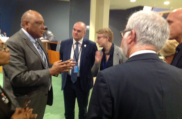 Minister Trotman makes a point to members of the Italian delegation led by Deputy Minister of the Environment, Silvia Velo, on the sidelines of the meeting