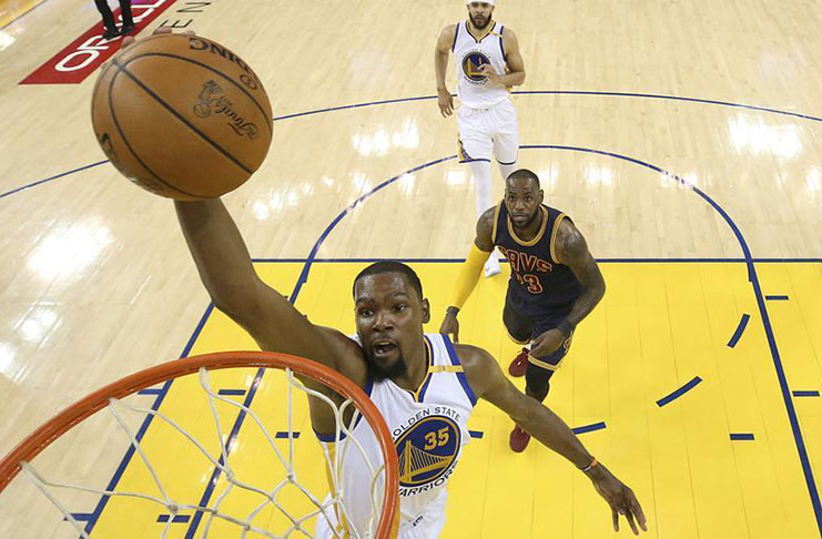 Golden State Warriors forward Kevin Durant dunks in front of Cleveland Cavaliers forward LeBron James during the NBA Finals. (AP)