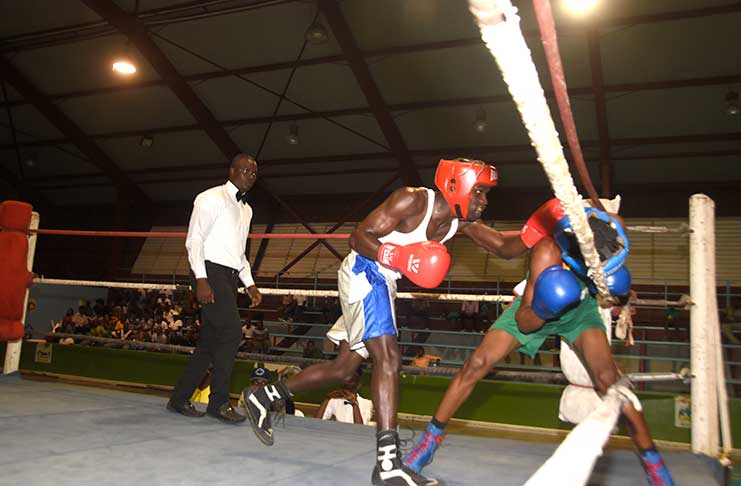 VBG’s Kelvin Moore (left) connects with a left cross to the head of GDF’s Clinton Clarke during their 56kg contest at the National Gymnasium on Wednesday night.