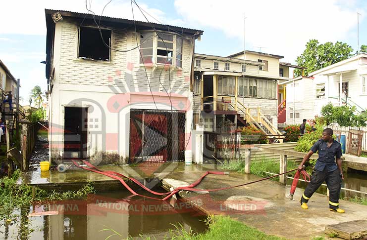 A fireman in action at the scene of the fire. (Adrian Narine photo)