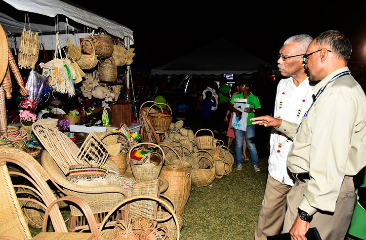 President of the Essequibo Chamber of Commerce, Mr. Deleep Singh, discussing craftwork on display at the Essequibo Agro and Trade Expo with President David Granger, who declared the event open