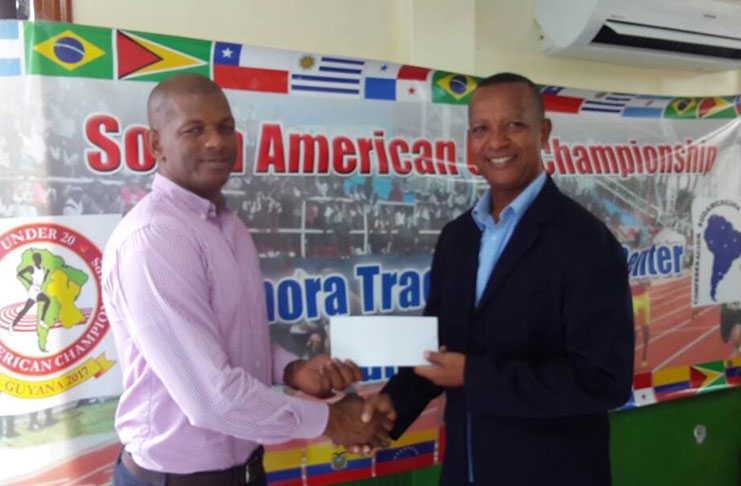 GOA vice-president Godfrey Munroe (left) hands over the sponsorship cheque to AAG president Aubrey Hutson.