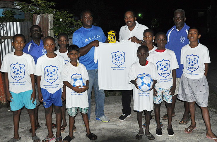 Ralph Green hands over one of the branded jerseys, along with the (finals) ball to EBFA president Franklin Wilson in the presence of association secretary Wayne Francois and Exco member Clive Matthews. The jerseys are being worn by the Grove players..