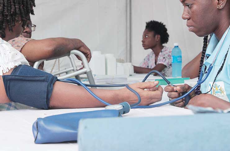 A patron having her blood pressure tested on Saturday at the fair by a Ministry of Public Health official