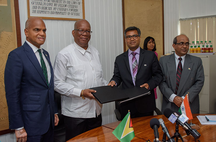 EXIM Bank’s resident representative, Sailesh Prashad (right) hands over signed copies of the LoC agreement to Finance Minister, Winston Jordan, in the presence of Guyana’s Ambassador to India, Dr David Pollard