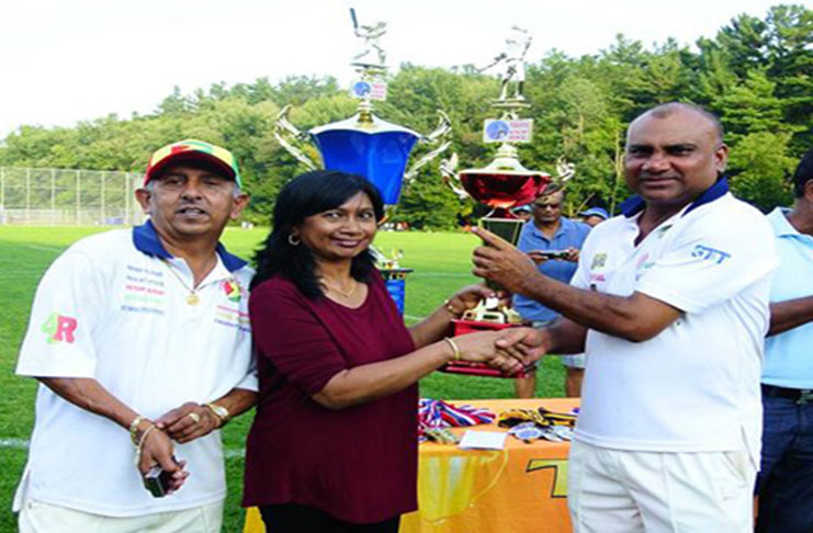 GFSCA skipper Rickey Deonarine collects the runner-up trophy for the Masters category at the inaugural tournament in September 2015. President Ramchand Ragbeer is at left.