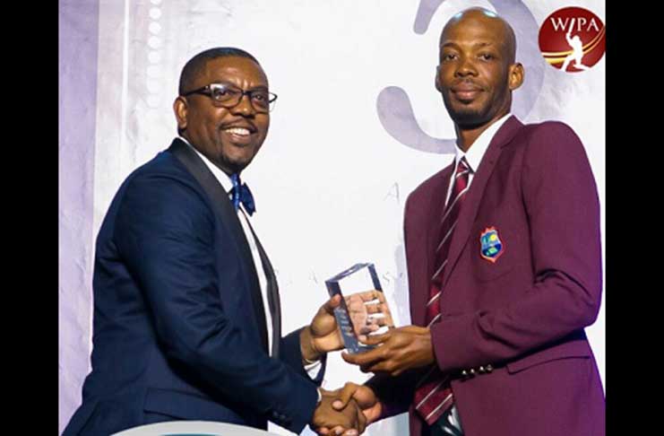 Roston Chase receives his Test Cricketer-of-the-Year award from Cricket West Indies president, Dave Cameron. (Photo courtesy West Indies Players Association)