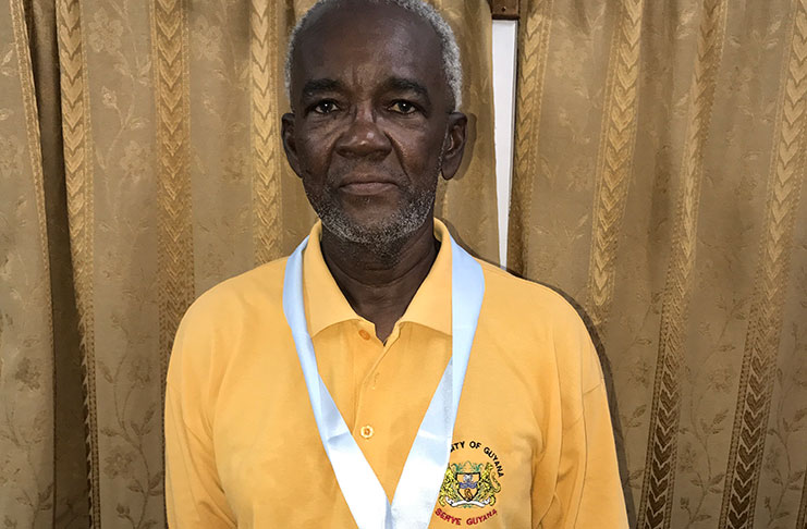 Veteran sports administrator, Claude Blackmore proudly displays his medal