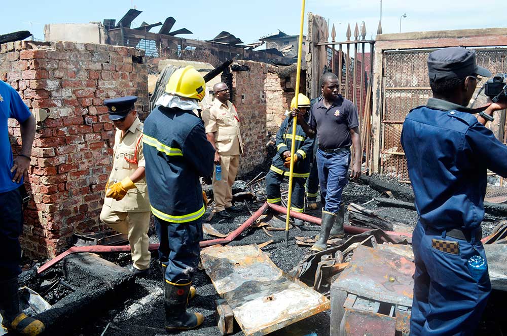 Firemen combing through the rubble for bodies, weapons, ammunition and other prison system valuables on Monday. This is just inside the main gate (Bert Wilkinson photo)