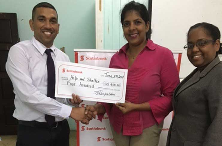 Help and Shelter Director, Niveta Shivjatan, accepts the donation from proud Scotiabankers: Andy Budhu and Natalie Noel