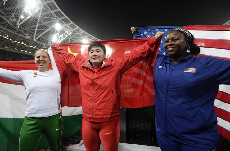 Lijiao Gong of China celebrates winning gold with silver medallist Anita Marton of Hungary (L) and bronze medallist Michelle Carter of the U.S. (R).