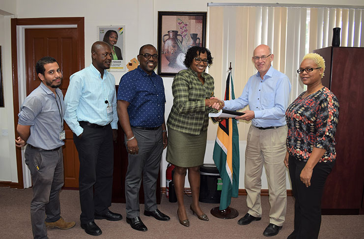 Minister within the Ministry of Public Infrastructure, Hon. Annette Ferguson (third, right) receives the completed Feasibility Study and Design for the new Demerara Harbour Bridge from Mr. Ariel Mol of LievenseCSO (second, right). With them are the members of the project team: DHBC General Manager and Project Manager, Mr. Rawlston Adams (third, left); Chief Transport and Planning Officer at MPI, Mr. Patrick Thompson (second, left); Senior Engineer (Transport and Planning), Mr. Ronald Roberts (left); and Transport Planning Officer (Economist) Ms. Ramona Duncan (right)