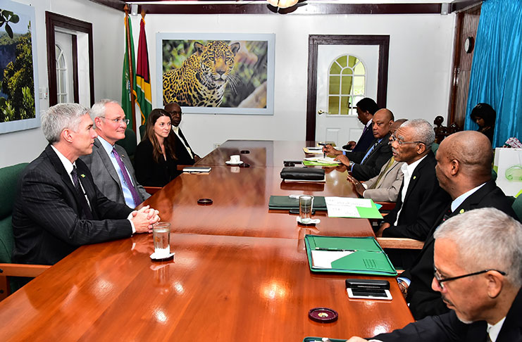 President David Granger makes a point to Mr. Darren Woods, Chairman and Chief Executive Officer of ExxonMobil as officials of the Government and ExxonMobil look on.