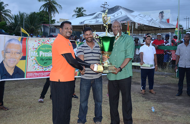 Roy Jaferally receives the winning trophy and cash prize from Minister Joseph Harmon and Satyna Kishun collects from Kares Engineering.