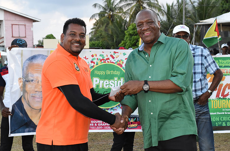 Minister Harmon presents the Man-of-the-Match prize to Mr Roy Jafarally of the Grill Master Team.